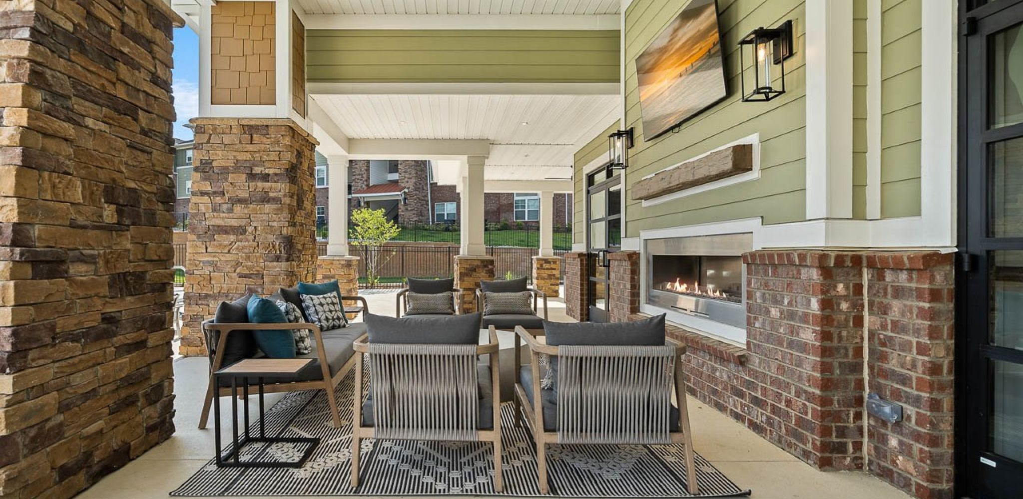 Hawthorne Waterstone resident outdoor amenity area with a fireplace and surrounding seating